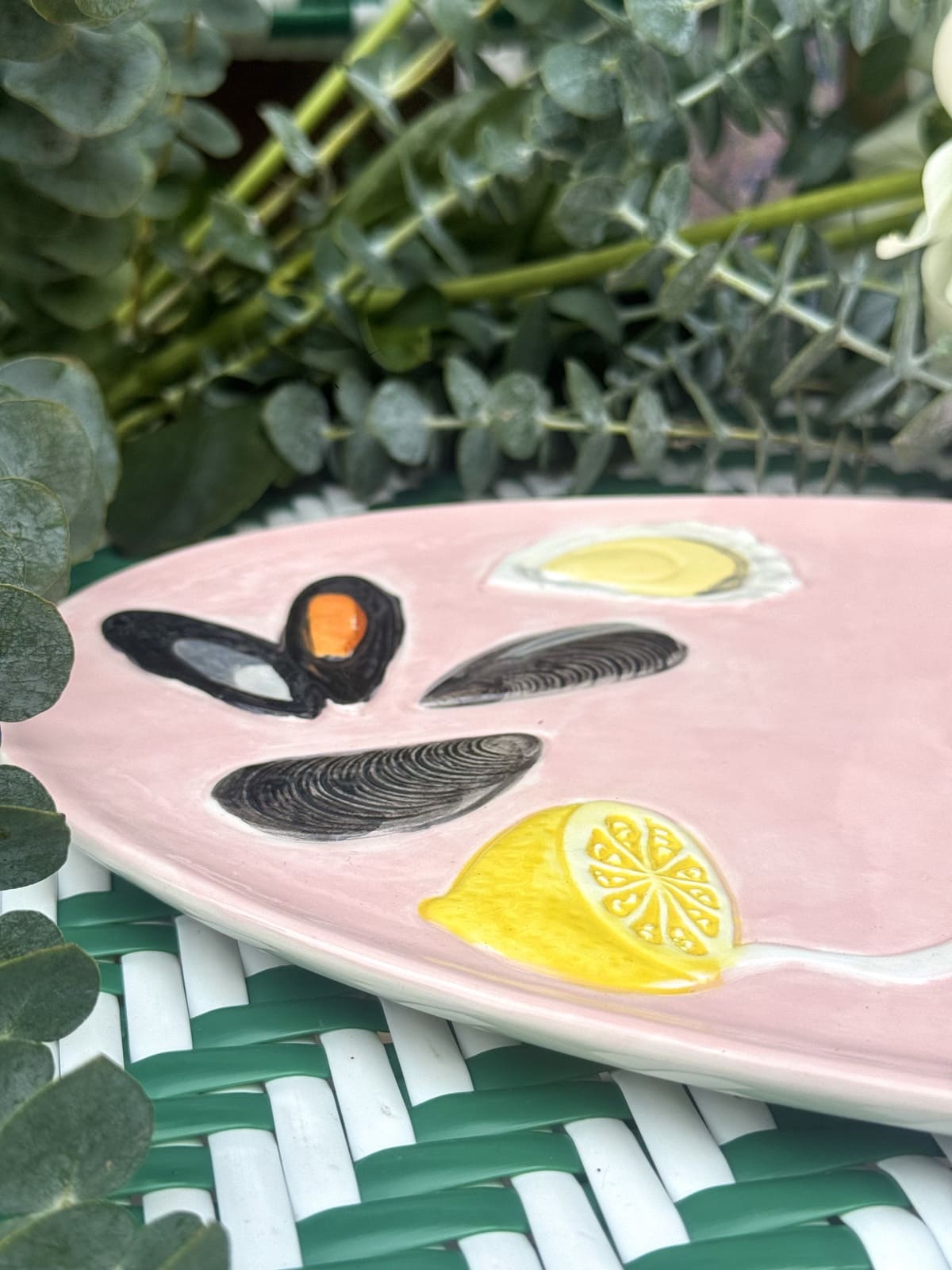 Détail peint à la main : huîtres, moules et tranches de citron sur plat rose