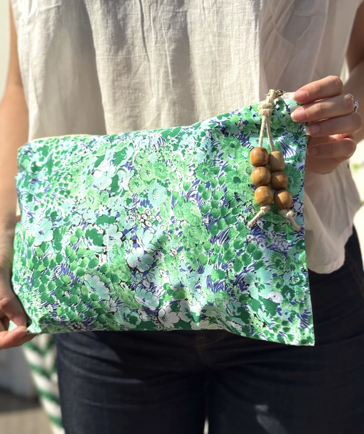 Femme portant une pochette verte imprimée de petites fleurs