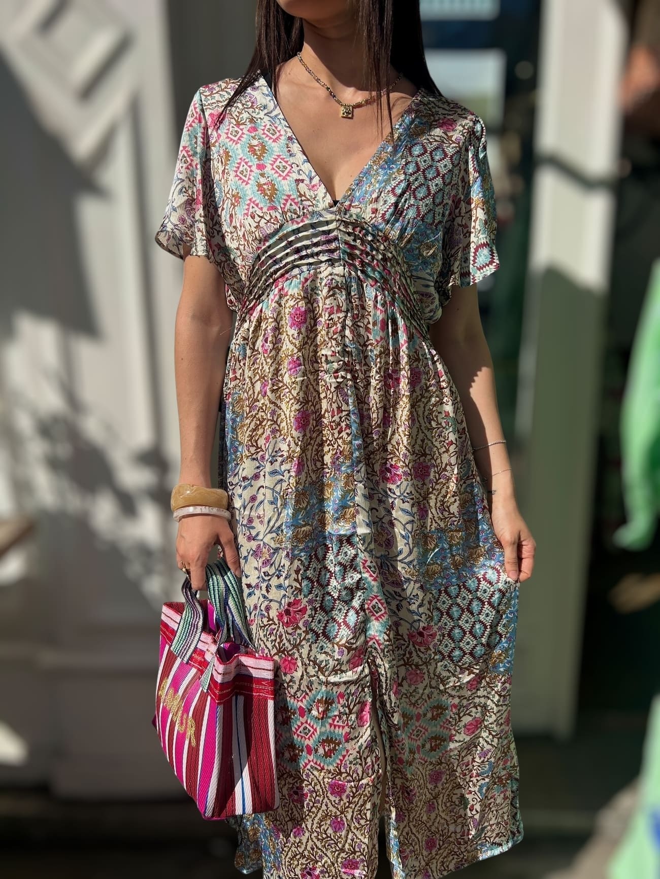 Femme portant une robe en soie imprimé bleu et rose taille empire