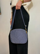 Femme portant un sac en bandoulière en daim avec tenue chic