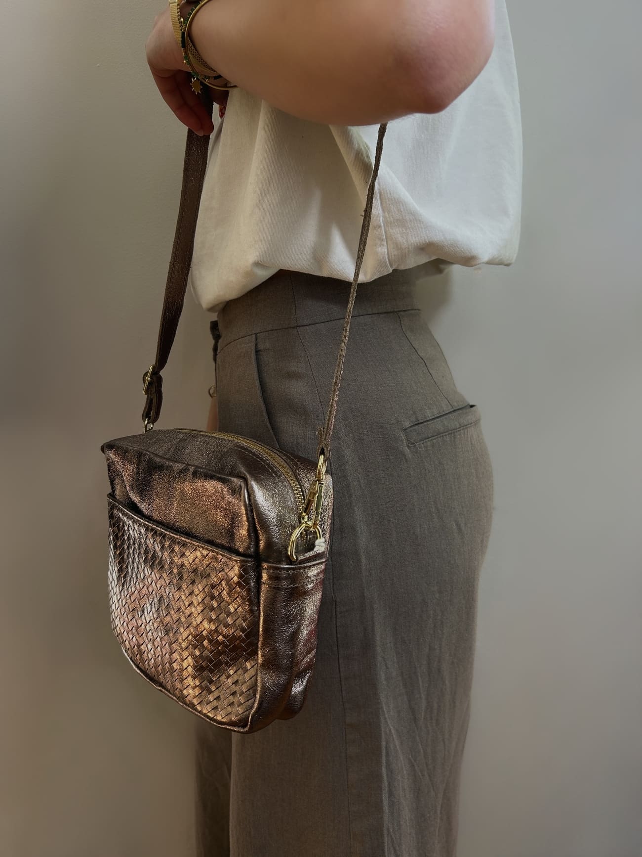 Femme portant le sac taupe métallisé en bandoulière – look élégant et décontracté

