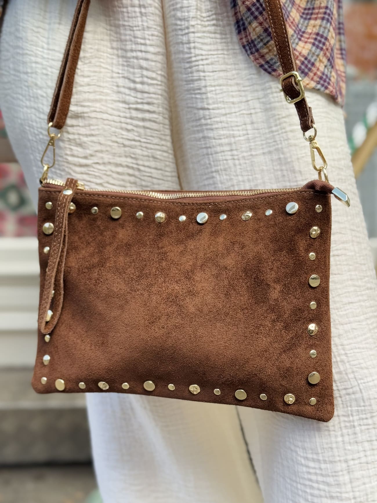 Gros plan sur le sac en daim - pochette marron orné de clous dorés