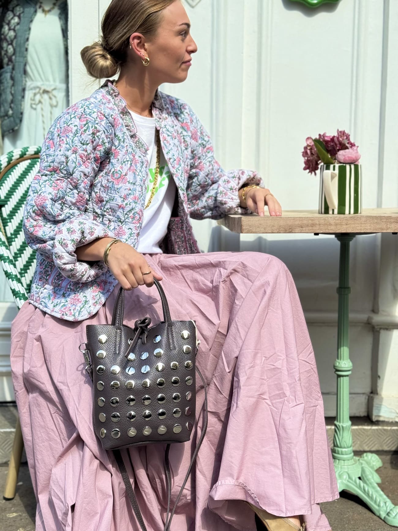 sac seau marron clouté porté par une femme assise 