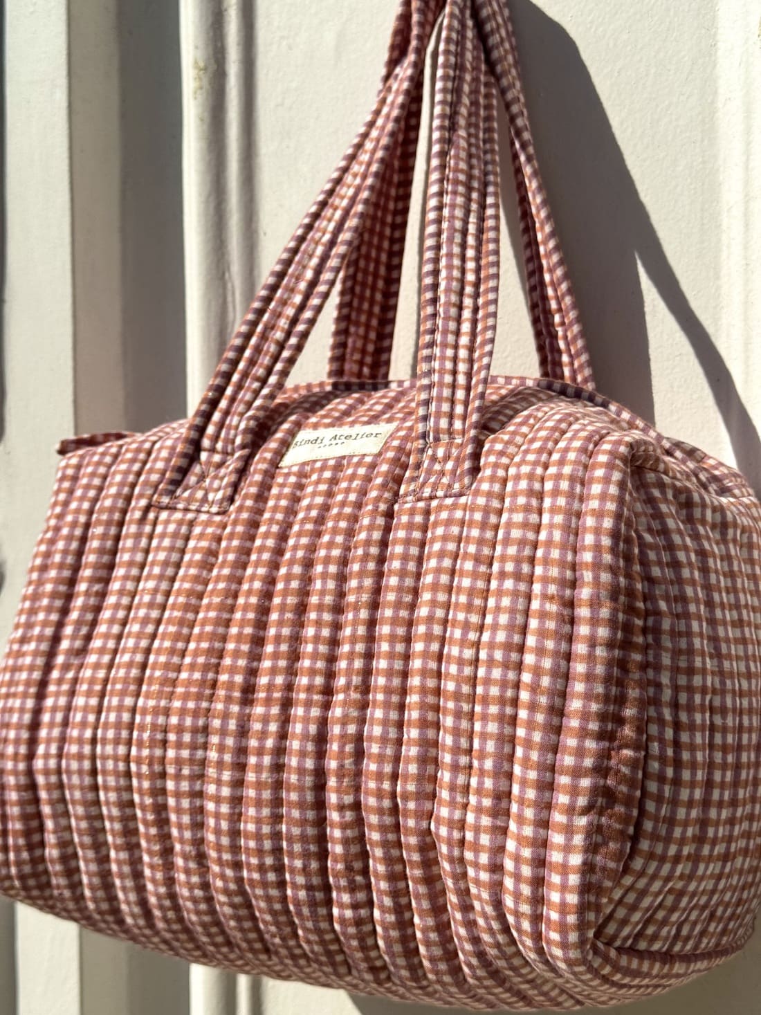 Sac matelassé à motif carreaux posé sur fond clair