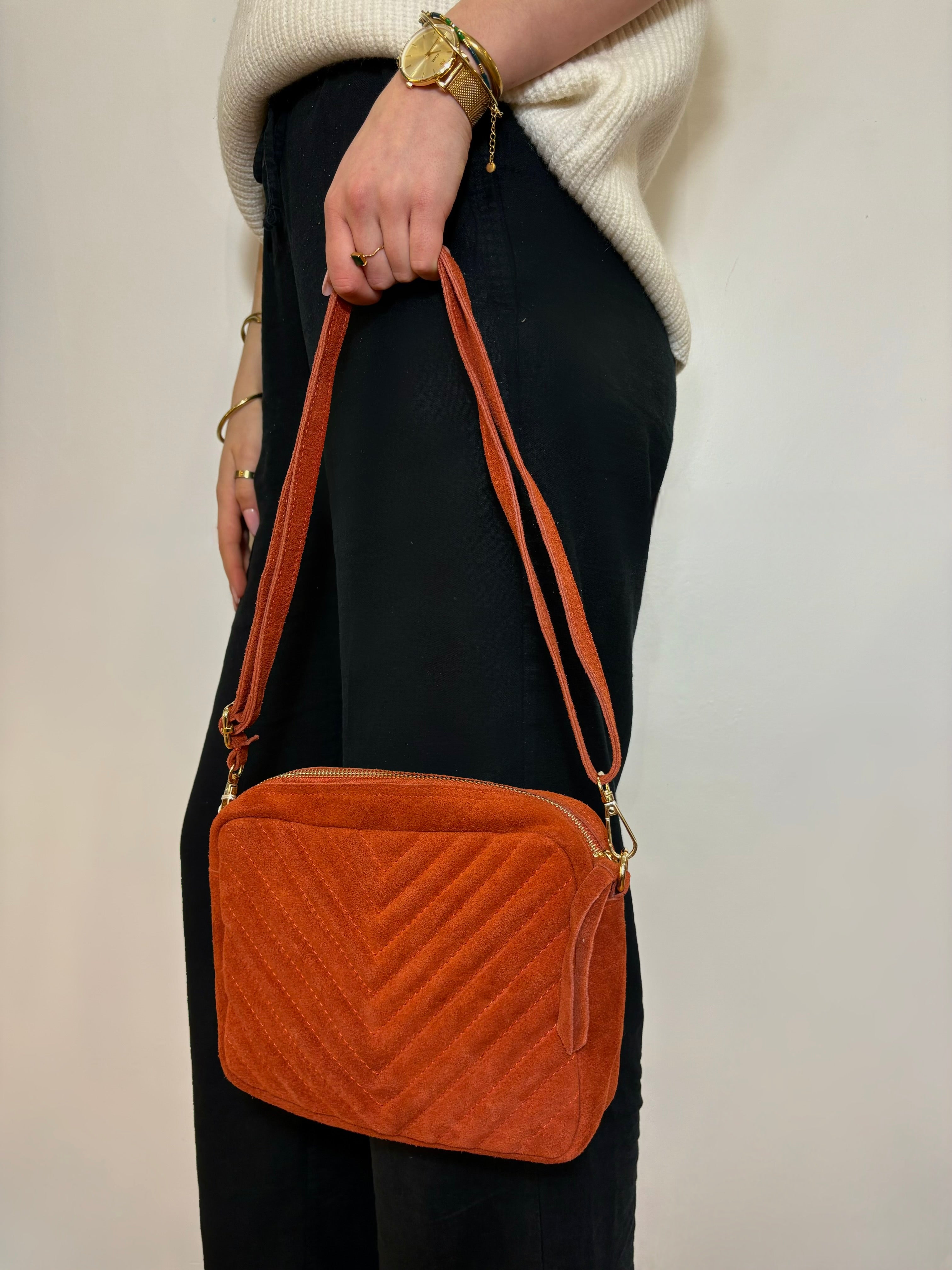 Détail des surpiqûres sur un sac en daim rouille