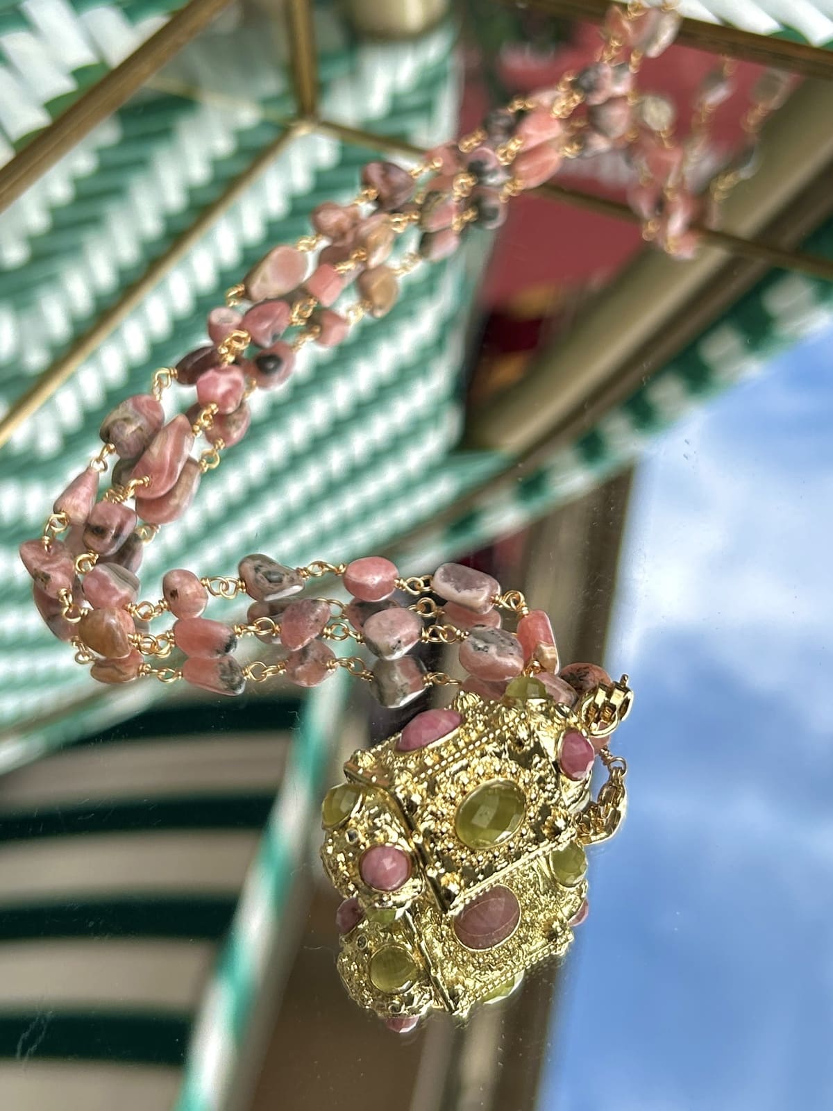 Gros plan sur le sautoir talisman avec perles roses délicates