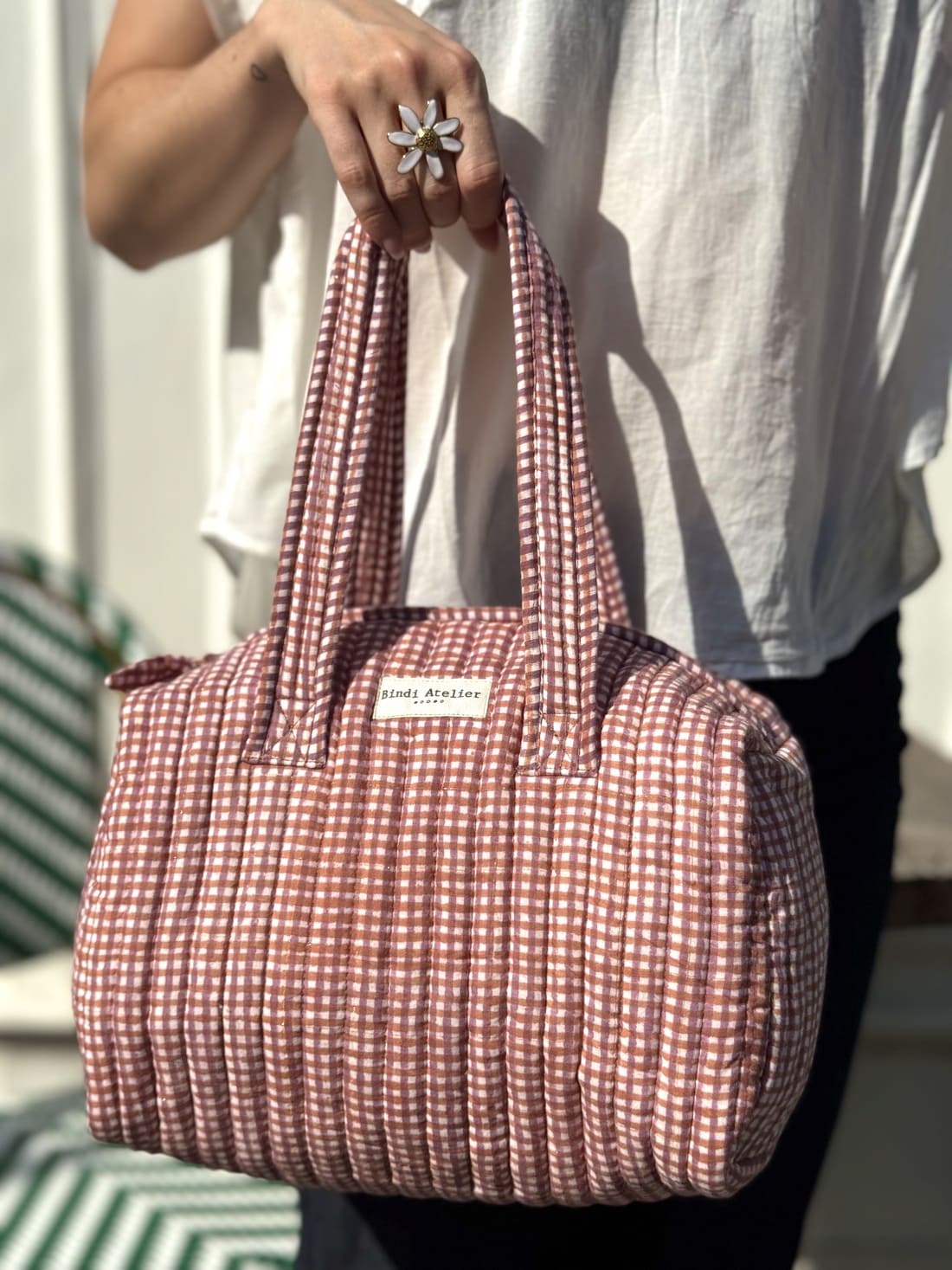 Femme portant un sac matelassé à imprimé carreaux