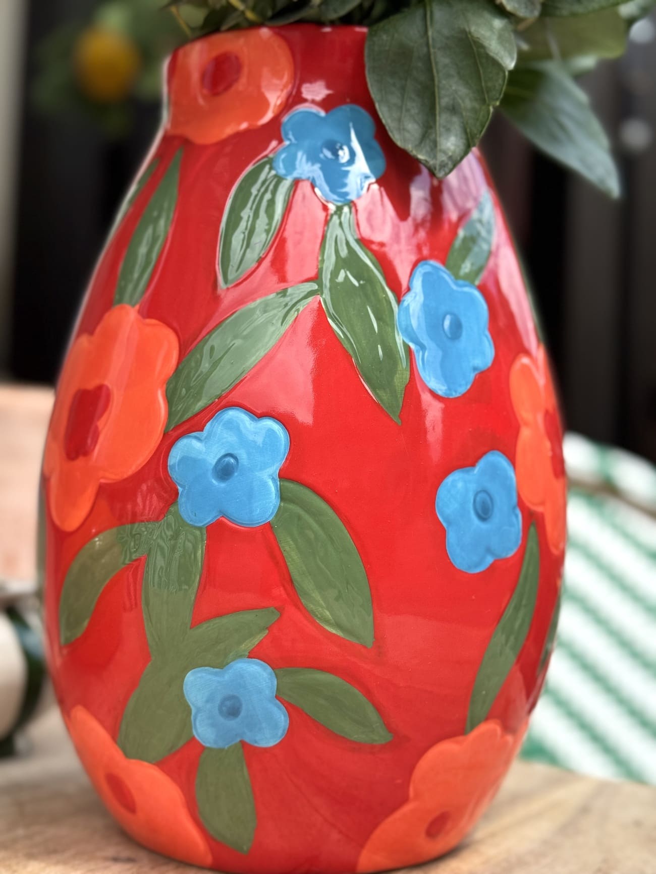 Détail de fleurs colorées peintes à la main sur vase rouge