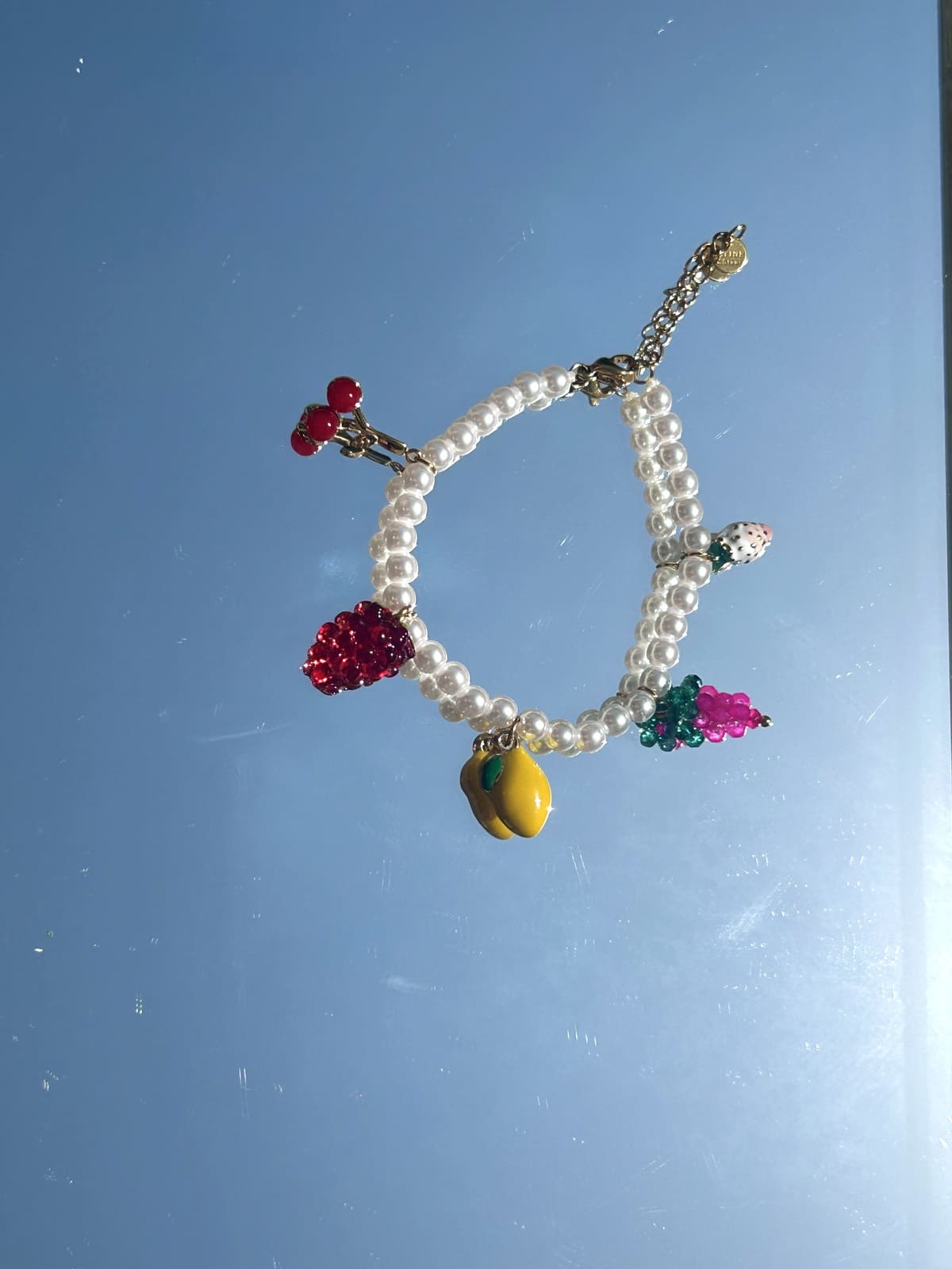 Zoom sur les breloques fruits et perles colorées du bracelet